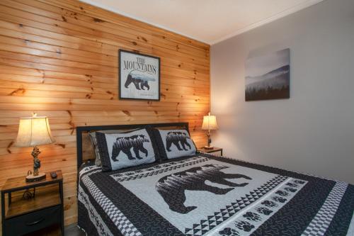 a bedroom with a bed and a wooden wall at Stunning mountain views with Community Amenities in Gatlinburg