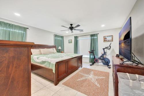 a bedroom with a bed and a flat screen tv at Sunny Waterfront Key Colony 3BR 3BA Villa w Dock in Key Colony Beach
