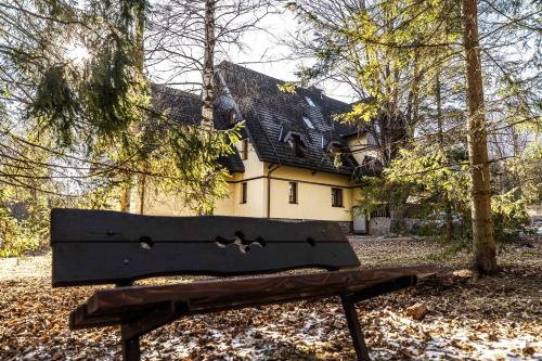 a park bench in front of a house at Apartment Tatry Comfort - Tatranská Lomnica in Vysoké Tatry