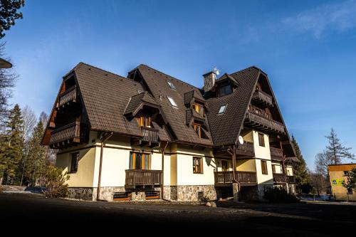 a large house with a gambrel roof at Apartment Tatry Comfort - Tatranská Lomnica in Vysoké Tatry