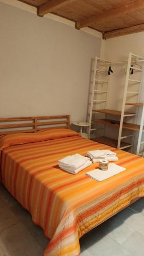 a large orange bed with towels on top of it at Domus Case Vacanze civico del mare in Castellammare del Golfo