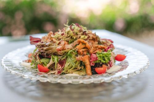 a salad on a glass plate on a table at Gartenhotel Maria Theresia in Hall in Tirol