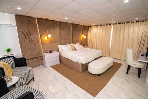a bedroom with a bed and a couch and a desk at Crown Heights Apartment in Lagos