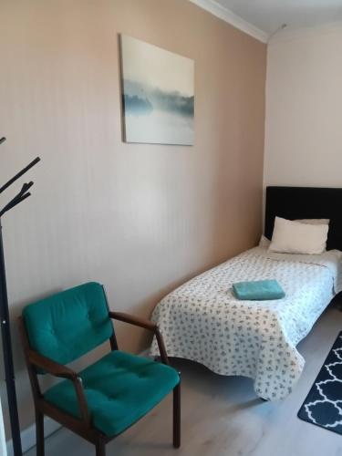 - une chambre avec un lit et une chaise verte dans l'établissement Gula Villan Värdshus, à Glommersträsk