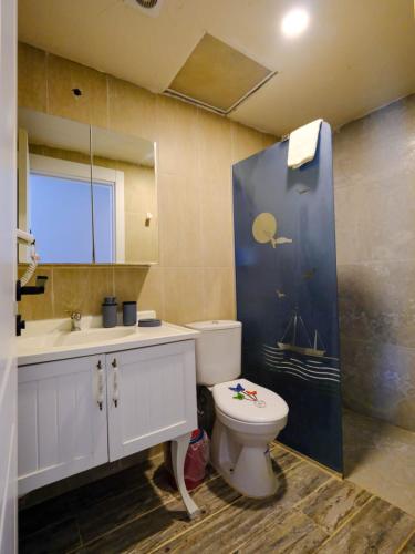 a bathroom with a toilet and a sink and a mirror at KUPALA BEACH HOTEL in Büyükkeçeli