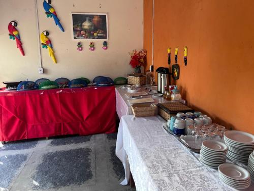 a table with a red table cloth and plates on it at Pousada Chácara do Coqueiro in Barreirinhas