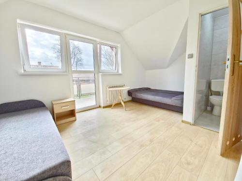 a bedroom with a bed and a toilet and windows at Kompleks domków na Mazurach dla grupy 15 osobowej in Sędańsk