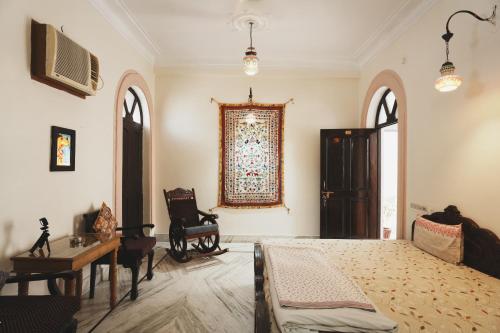 a bedroom with a bed and a table and a chair at Kanhaia Haveli in Pushkar