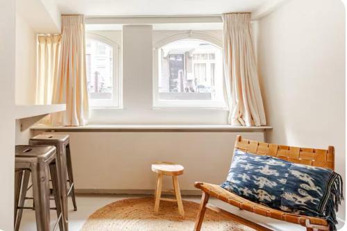Una sala de estar con una silla y una ventana. en Luxury canal suite in the best location of Amsterdam !!!, en Ámsterdam