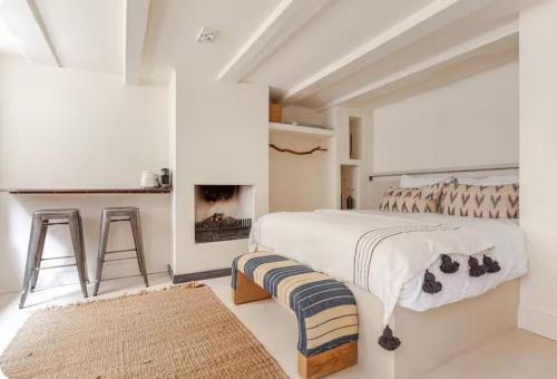 Un dormitorio blanco con una cama y una chimenea. en Luxury canal suite in the best location of Amsterdam !!!, en Ámsterdam