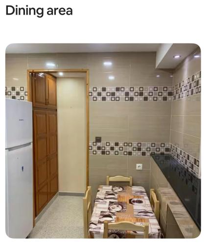 een eethoek met een tafel en een koelkast bij Birkhadem Openspace in Alger