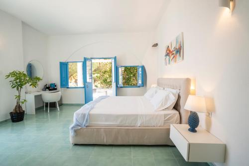 1 dormitorio con cama, mesa y lavamanos en Borgo del Cannitello Romantic Boutique Resort, en Vulcano