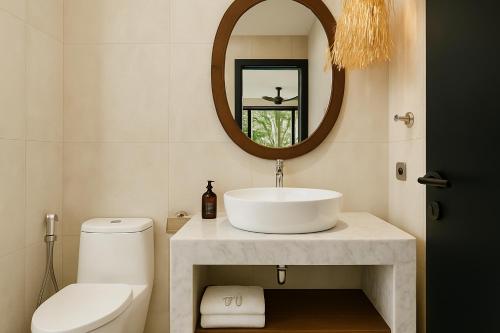 a bathroom with a sink and a mirror at Sunny Aparts 2 in Canggu