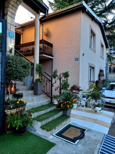 a house with stairs and flowers in front of it at Family Apartment in Cetinje