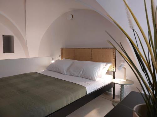 een slaapkamer met een bed en een potplant bij VIALI Guest House in Fasano