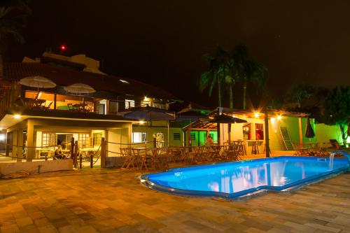 a swimming pool in front of a house at night at Hostel Costa Terral in Matinhos