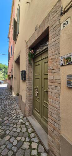 una puerta verde en el costado de un edificio en Casa Vacanze Piccolpasso 20, en Urbania