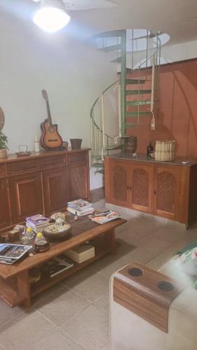 a living room with a table and a guitar at Aconchego jacaroa in Maricá