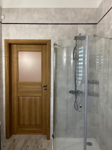 a bathroom with a shower with a wooden door at Warmińskie Lokum in Woryty