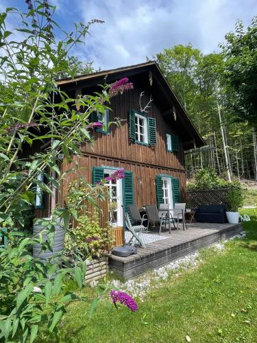 グルントルゼーにあるFerienhaus s Manzのポーチとパティオ付きのログキャビン