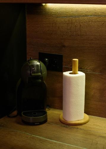 a roll of toilet paper sitting next to a coffee maker at Apartment with sea view 5 minutes from the beach in Budva