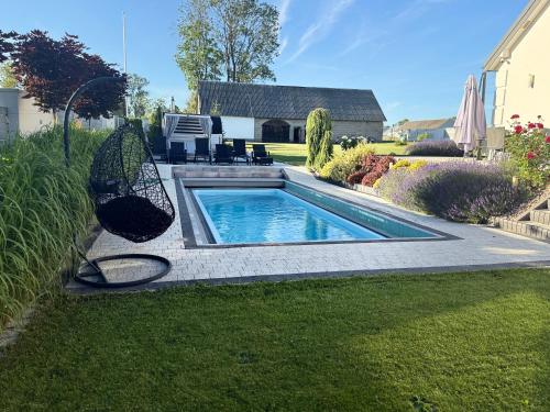 a swimming pool with a swing in a yard at Sieburczynianka in Wizna