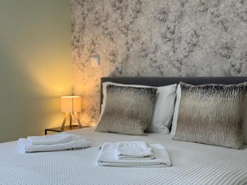 a bed with two towels sitting on top of it at Refúgio Rural - Gerês in Terras de Bouro