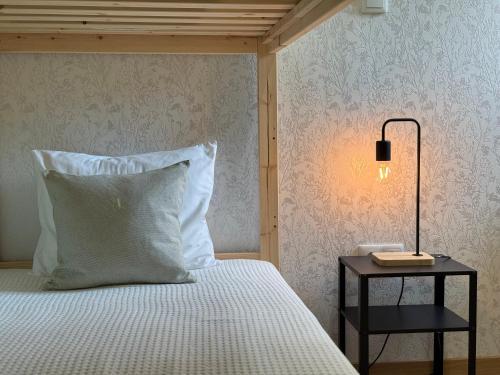 a bed with a pillow and a side table with a lamp at Refúgio Rural - Gerês in Terras de Bouro