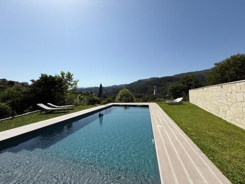 a swimming pool in the middle of a yard at Refúgio Rural - Gerês in Terras de Bouro