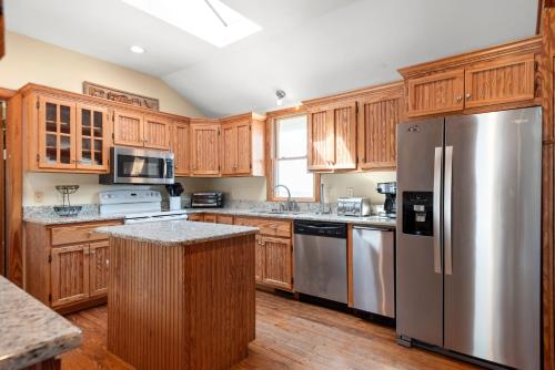 a kitchen with wooden cabinets and a stainless steel refrigerator at Its Beach Time in Nags Head