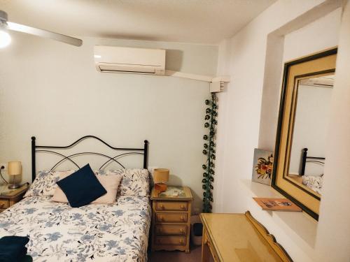 sypialnia z łóżkiem, komodą i lustrem w obiekcie Apartamentos Málaga Centro Hernán Ruiz de 4 a 8 Personas w Maladze