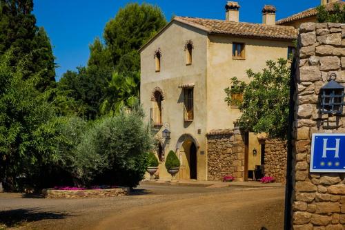 a stone building with a sign in front of it at Masía Durbá Hotel in Castellnovo
