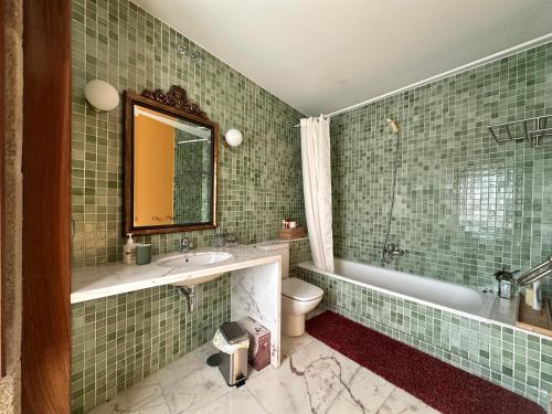 Un baño con lavabo, bañera e inodoro. en Casa do Bidueiro, en Luou
