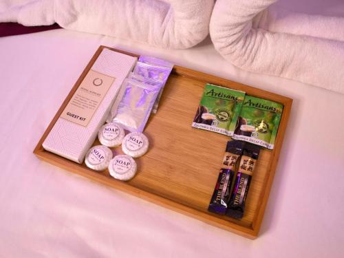 a wooden tray with cosmetics and books on a bed at Casa Bella Tagaytay in Ulot