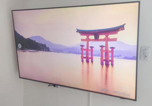 a television screen with a picture of a torii gate at Cobertura duplex com Jacuzzi e vista espetacular para a praia e a cidade in Praia Grande