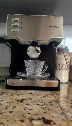 a espresso machine sitting on a counter with a cup at Cobertura duplex com Jacuzzi e vista espetacular para a praia e a cidade in Praia Grande