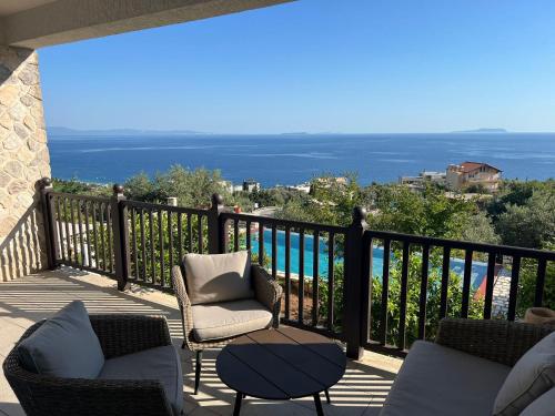 a balcony with chairs and a view of the ocean at Villa Horizon Dhermi in Dhërmi