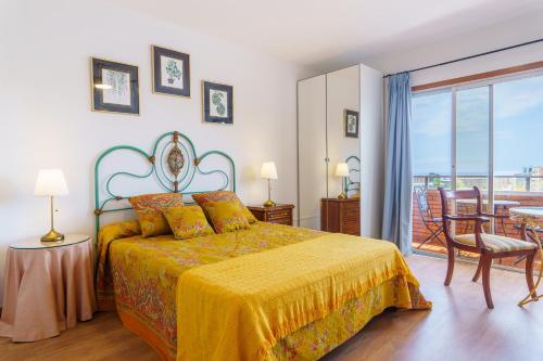 a bedroom with a bed with a yellow bedspread and a balcony at Living Sol - Centric Urban Room in Santa Cruz de Tenerife