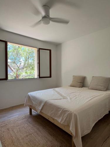 een witte slaapkamer met een bed en een raam bij Grande maison familiale Leucate Village in Leucate
