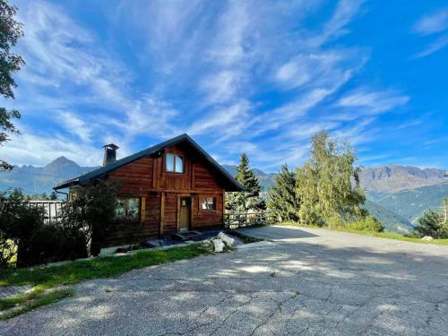 une maison en bois sur une colline avec une route dans l'établissement Chalet spacieux proche pistes et centre, animaux acceptés et parking - FR-1-505-75, à Crest-Voland