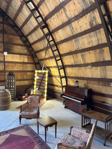 a room with a piano and chairs and a table at Domes Town by ANGAR in Vahagnadzor