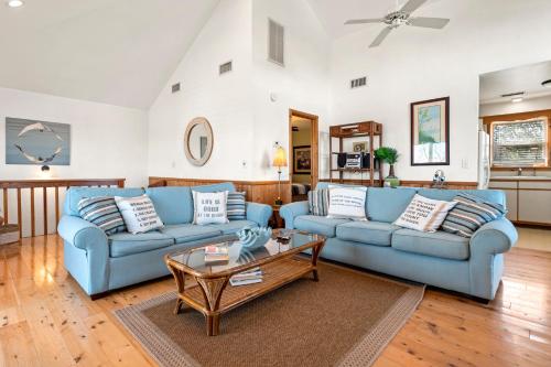a living room with two blue couches and a table at Kikis Retreat in Duck