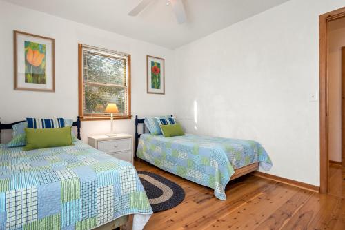 a bedroom with two beds and a window at Kikis Retreat in Duck