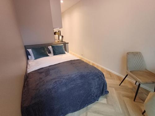a small bedroom with a bed and a chair at Luise LuXe Suites in Tallinn