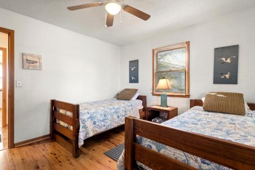 a bedroom with two beds and a ceiling fan at Kikis Retreat in Duck