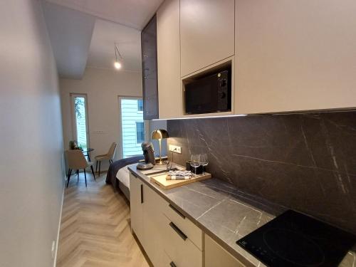 a room with a kitchen with a bed and a microwave at Luise LuXe Suites in Tallinn
