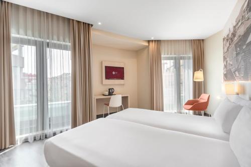 a hotel room with a bed and a large window at EXE Liberdade in Lisbon