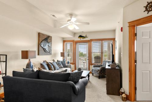 a living room with two couches and a ceiling fan at Knot Of Sound Mind in Nags Head