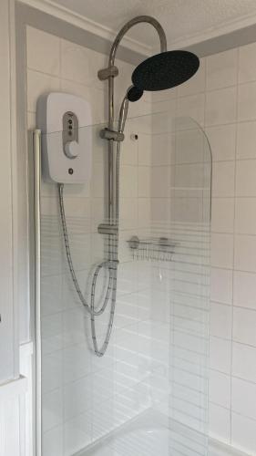 a shower with a shower head in a bathroom at Beachcomber, Two bed Chalet on Sunbeach Holiday Park - Sleeps 4, pet friendly, FREE pool and entertainment passes included - plus WiFi - only 300m from the beach! in Scratby