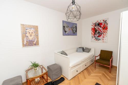 ポズナンにあるArtBase - cozy and close to everywhereの白いソファが備わる壁画のある客室です。